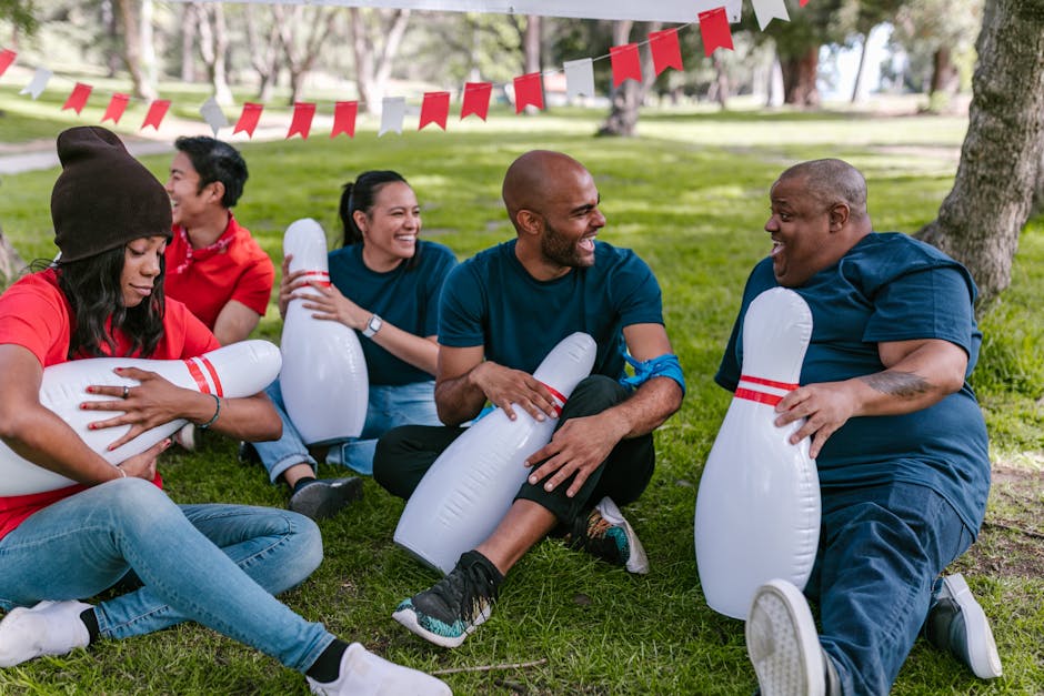 A diverse group of adults engaging in fun outdoor team-building activities in a park.