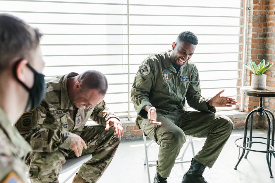 Military personnel sharing a joyful moment during indoor group session, promoting mental health.