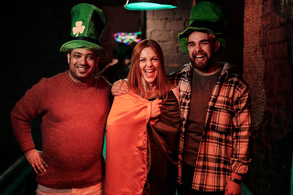 Group of friends celebrating St. Patrick's Day with joy and laughter indoors.