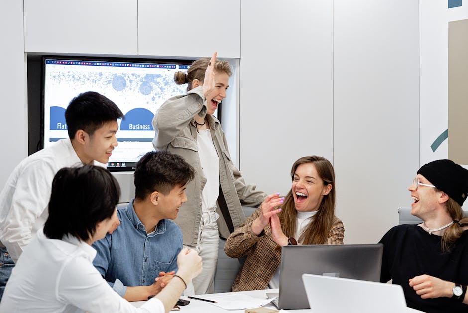 A diverse group of professionals celebrating a successful project in a modern office setting.