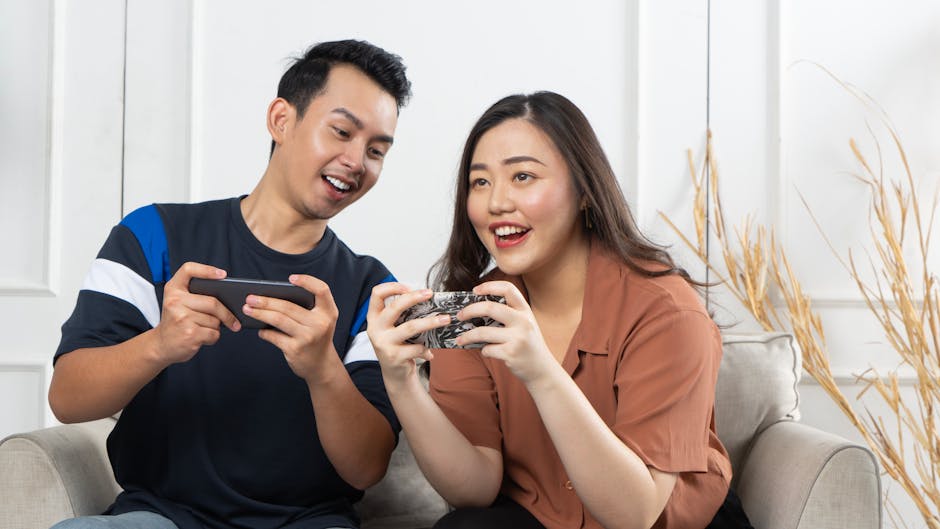 Young couple enjoying gaming on smartphones indoors, capturing joy and togetherness.