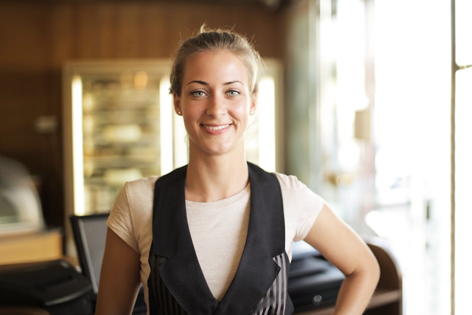 Portrait of a smiling blonde woman standing indoors, with a bright and friendly expression.