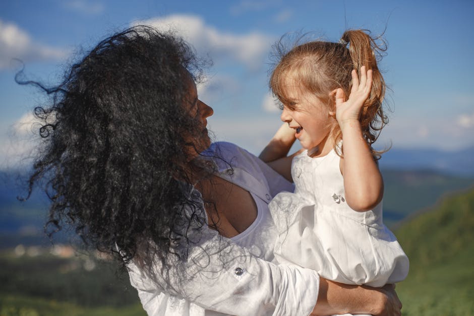 A joyful outdoor moment between a mother and daughter under the summer sky.