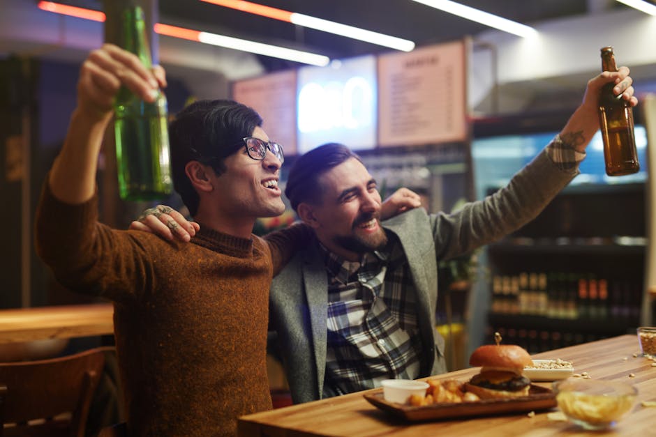 Two men enjoying drinks and food in a lively bar setting.