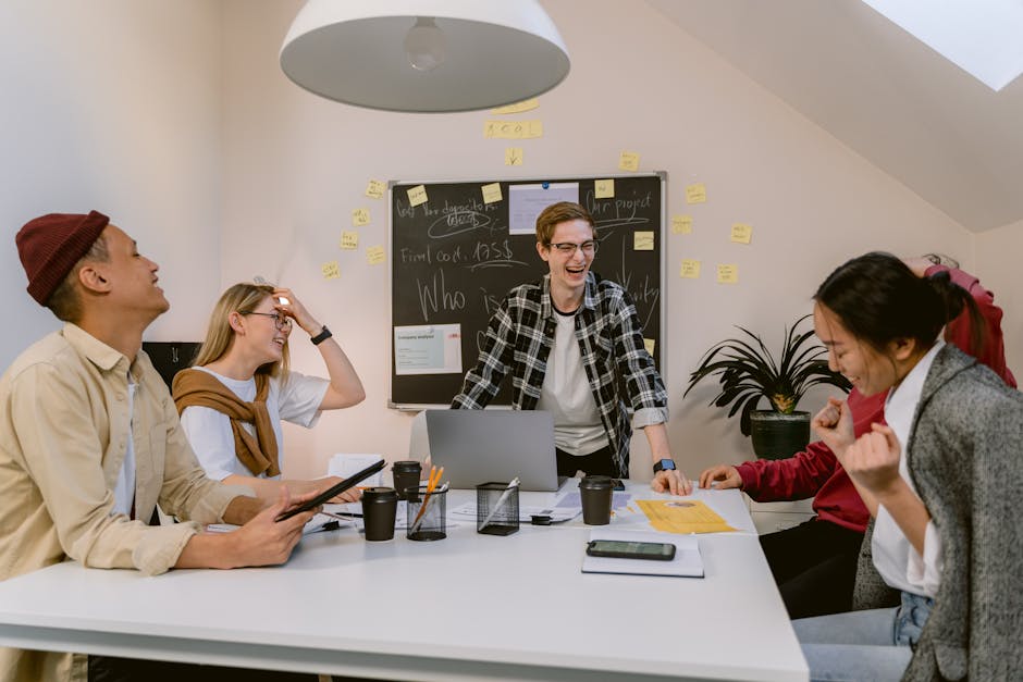 A cheerful and diverse team engages in a lively brainstorming session in a modern office environment.