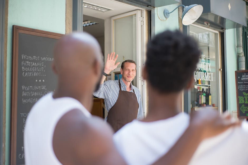 Friendly store clerk in Portugal waves at customers with warm welcome.