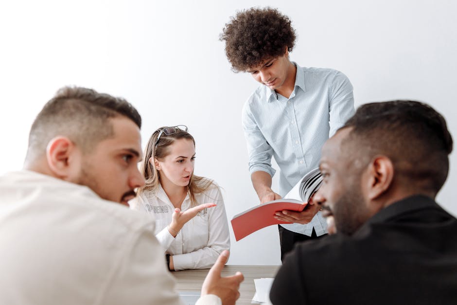 A diverse group of young professionals engaged in a brainstorming session in a modern office setting.