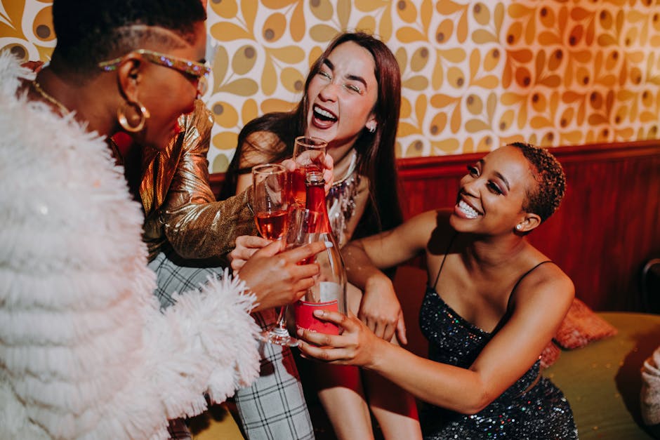 Three diverse women enjoying a lively indoor celebration, toasting with champagne and sharing laughter.