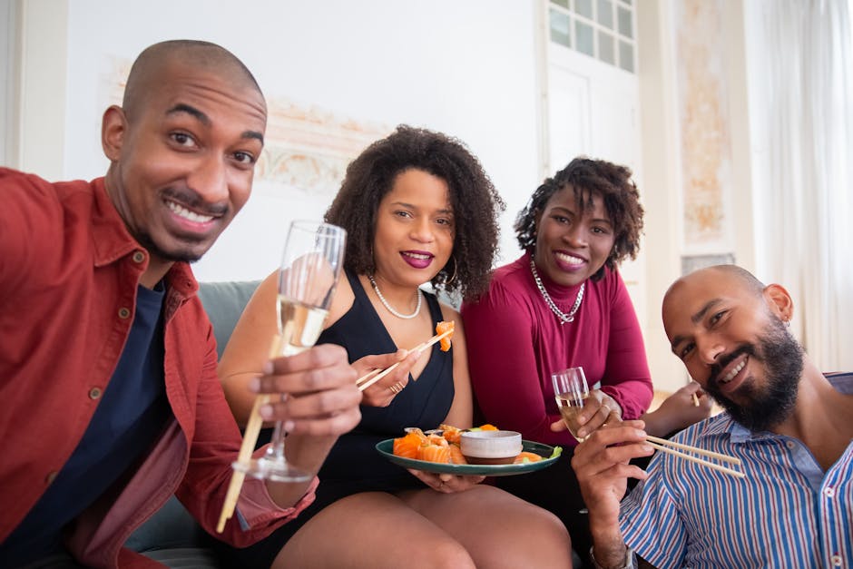 Friends enjoying a sushi dinner and champagne indoors, celebrating with smiles and cheer.