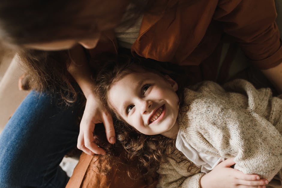 A heartwarming photo of a smiling child bonding with a parent indoors.