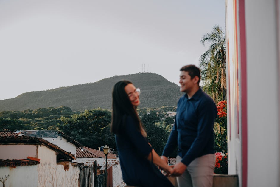 A loving couple shares a joyful moment outdoors at sunset with scenic views.