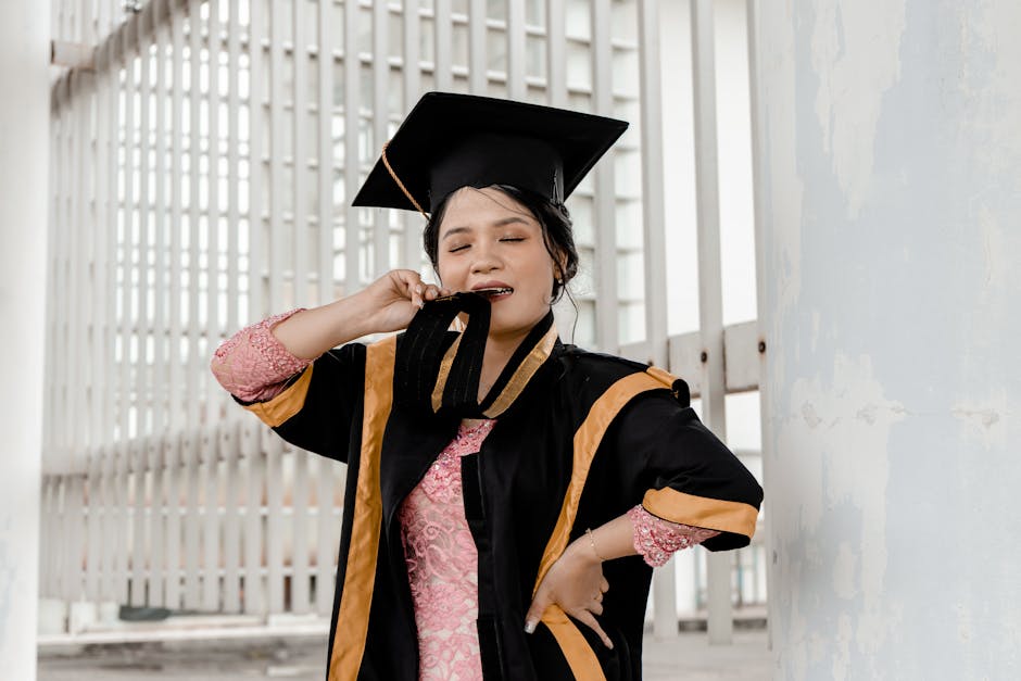 A joyful female graduate in academic dress holding a medal and celebrating her achievement.