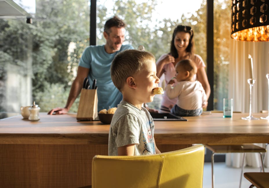 A joyful family gathers in a bright kitchen, enjoying breakfast and togetherness.