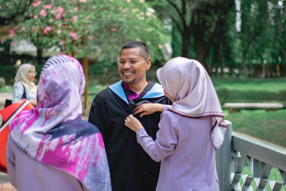 Group celebrates graduation outdoors in Shah Alam, Malaysia, exchanging smiles and joy.