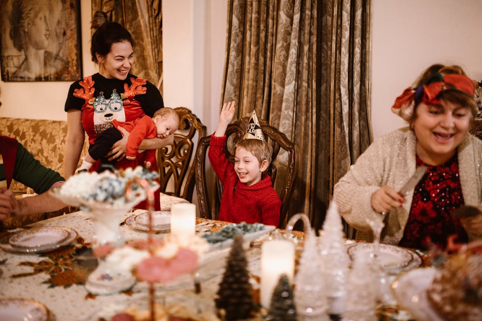 A joyful family celebrates Christmas around a dining table with children and festive decorations.