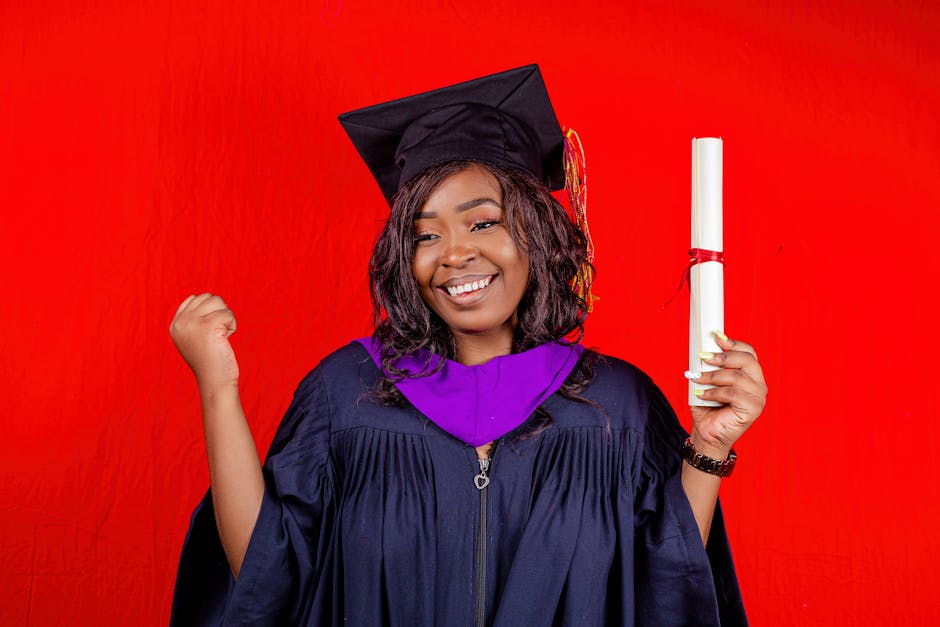 Happy young graduate celebrating with diploma against a red background.