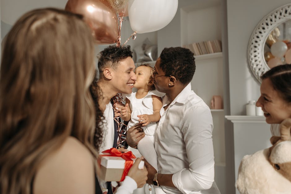 A diverse family celebrates indoors with balloons, gifts, and a joyful atmosphere.