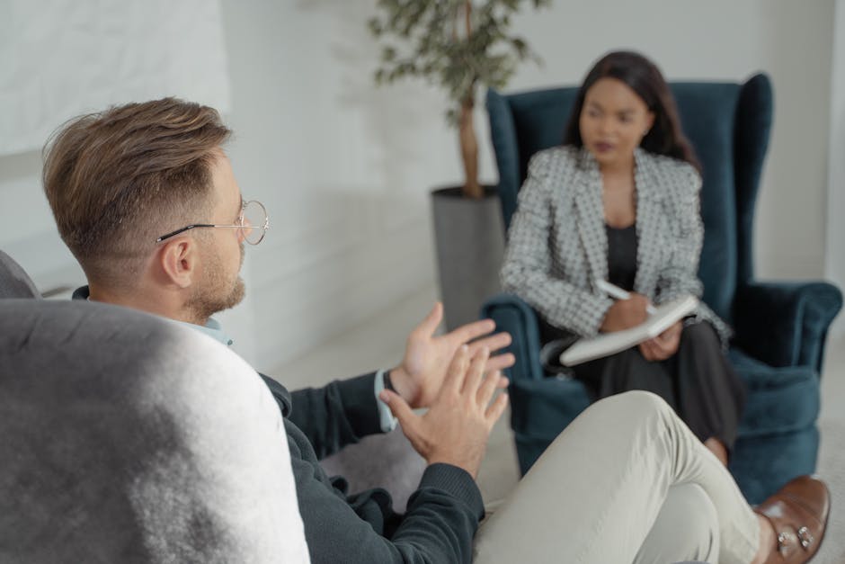 Two professionals engaged in a discussion in a modern interior with armchairs.