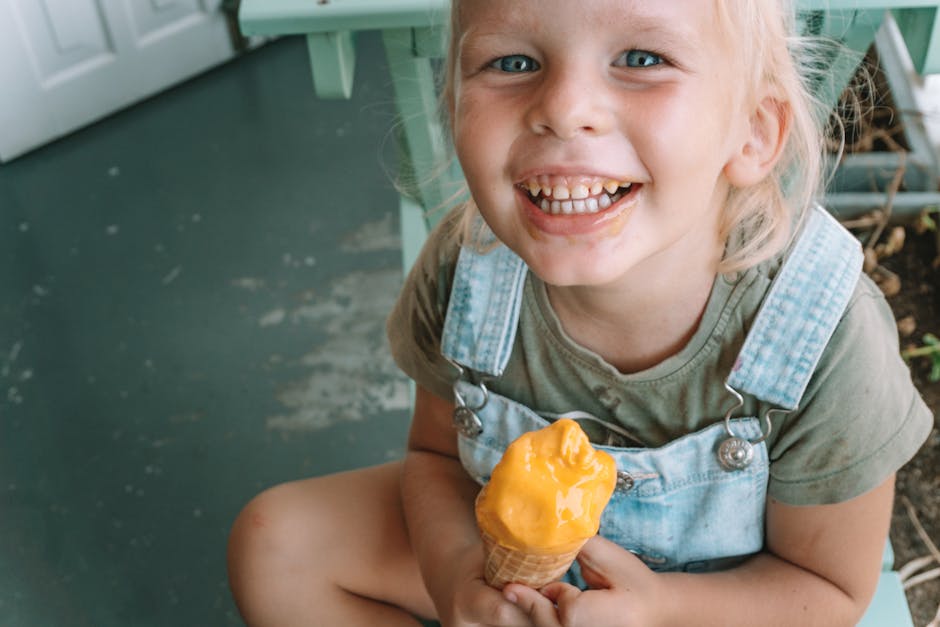 A happy child enjoying a delicious ice cream cone, sitting indoors on a summer day.