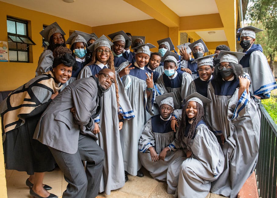 A joyful group of graduates posing for a portrait in their cap and gown.