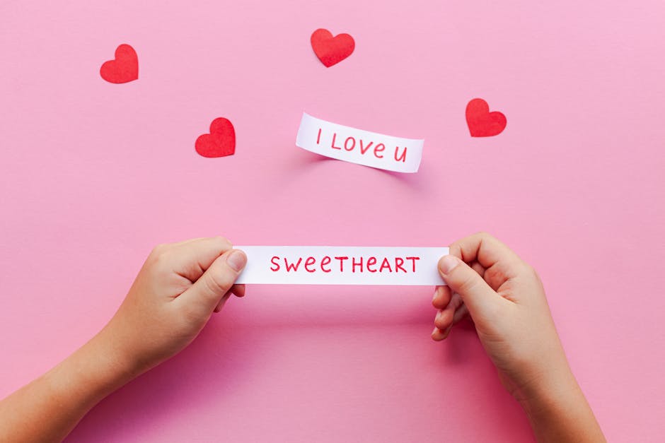 Hands holding love notes on pink background with red hearts. Perfect for Valentine's Day.