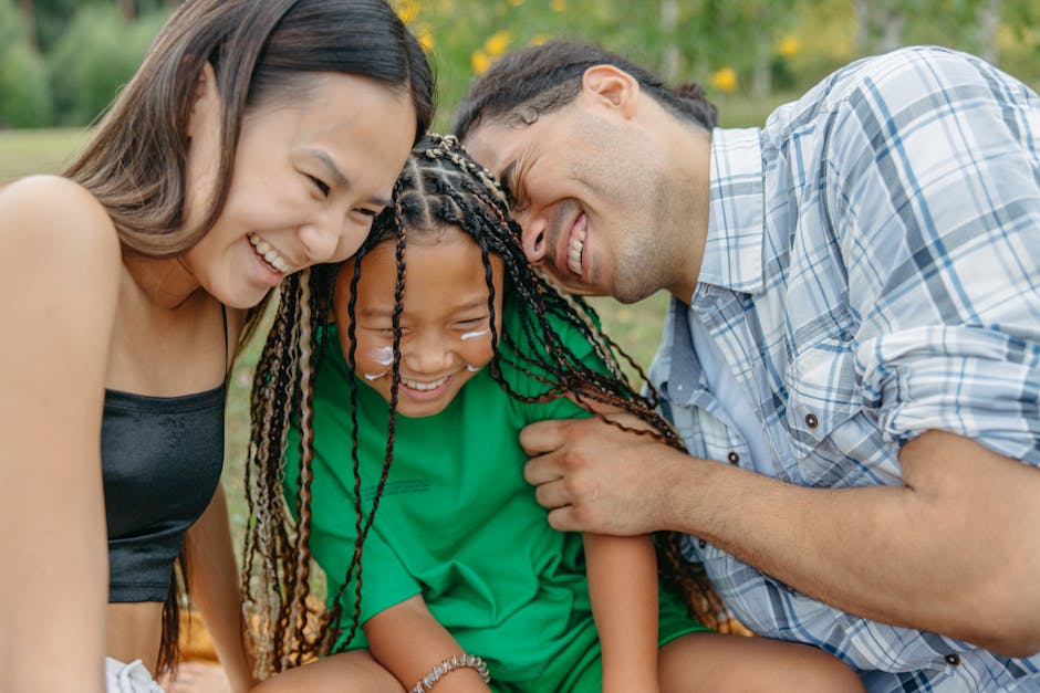 A joyful family spending time together in a sunny park, embracing happiness.