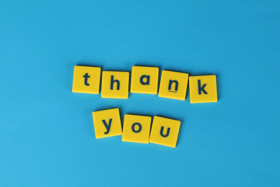 Bright yellow letter tiles spelling 'thank you' on a blue background, perfect for gratitude notes.