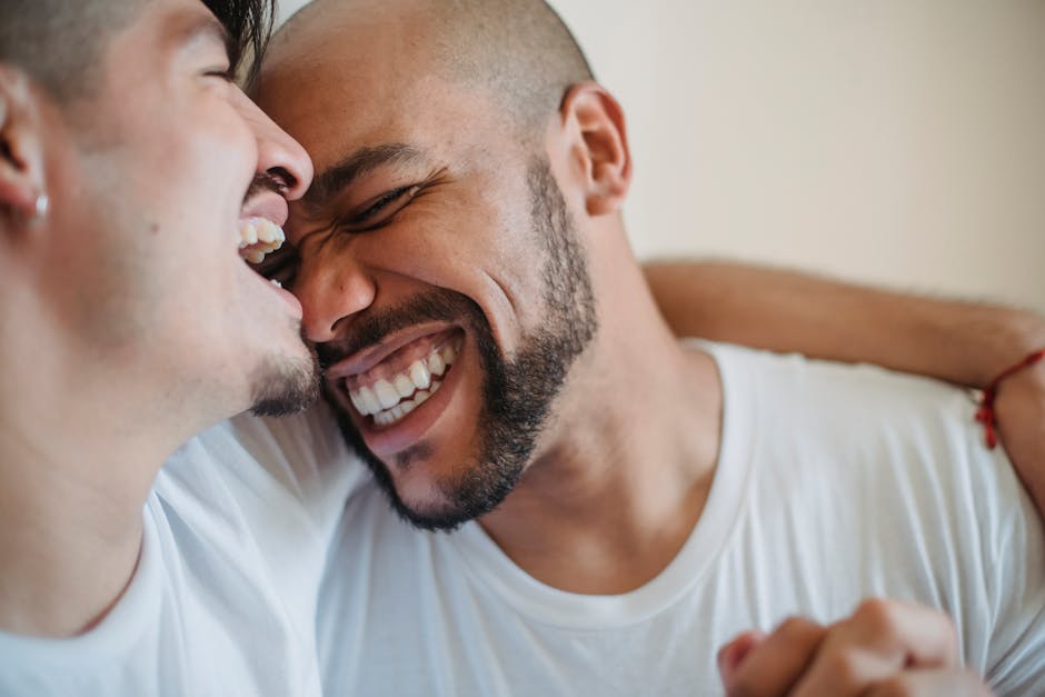 Close-up of a happy couple laughing and embracing in a cozy indoor setting.