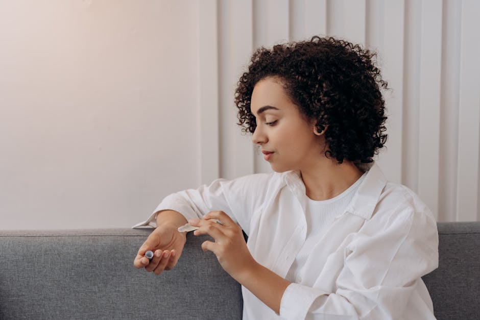 A young woman applies essential oil while relaxing indoors, promoting wellness and self-care in a calming environment.