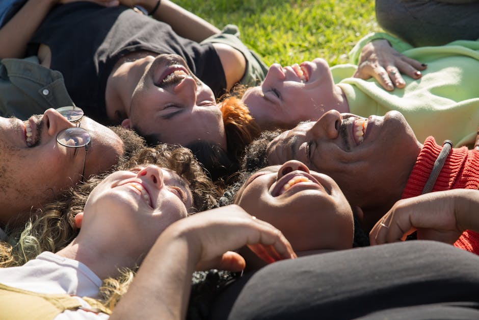 A diverse group of friends smiling and bonding on a sunny day outdoors.