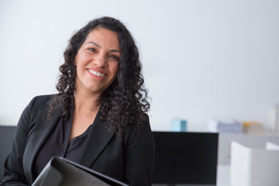 Cheerful woman in a corporate setting, exhibiting confidence and professionalism.