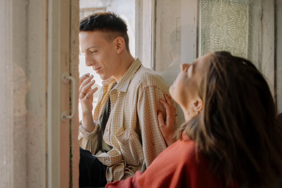 A young couple enjoying a peaceful moment together near a window.