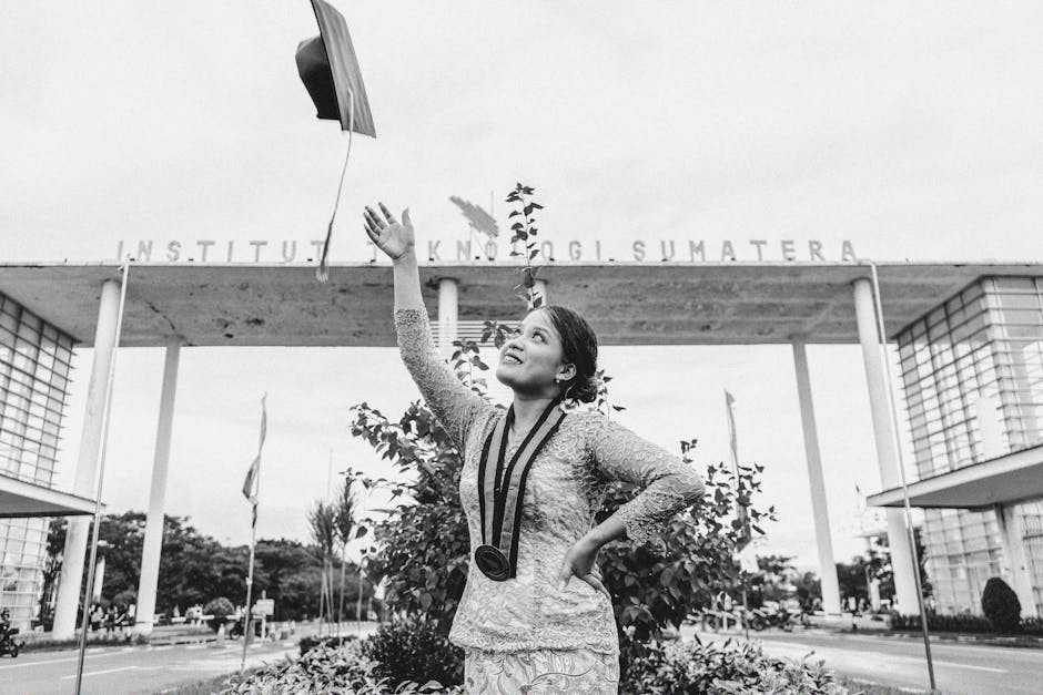 A graduate celebrates by throwing her cap outside Institut Teknologi Sumatera.