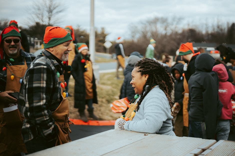 A joyful outdoor holiday event featuring people in festive Christmas elf costumes.