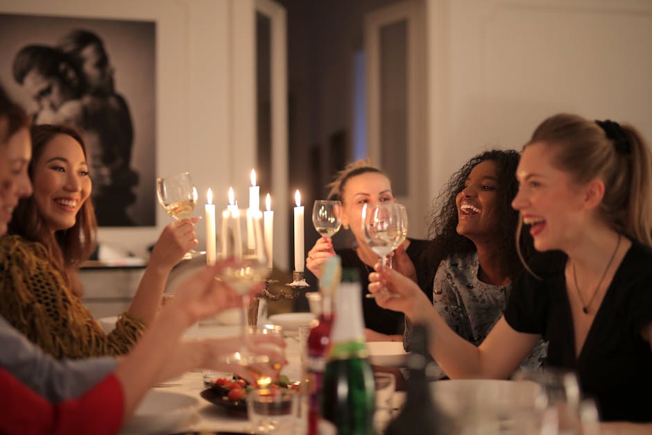 A group of women enjoying a lively dinner party with wine and candlelight, showcasing friendship and happiness.