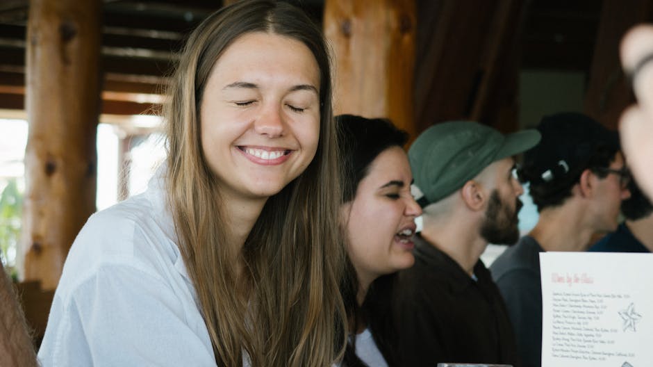 Smiling woman with friends socializing in a cozy indoor setting, capturing joy and friendship.