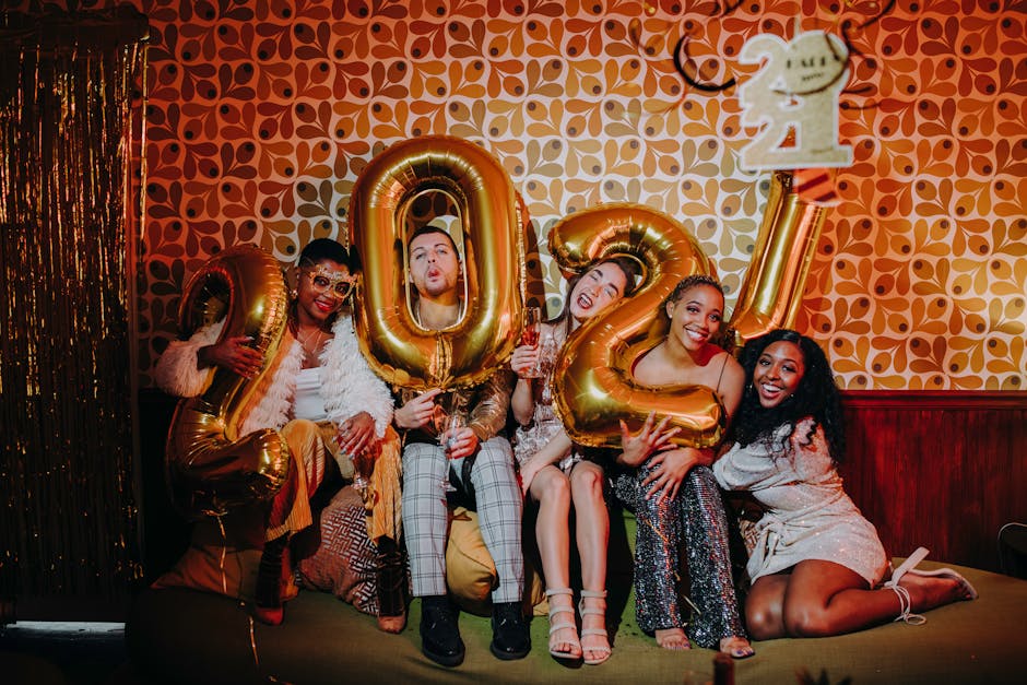 A joyful group of friends celebrating New Year's Eve with balloons and champagne.