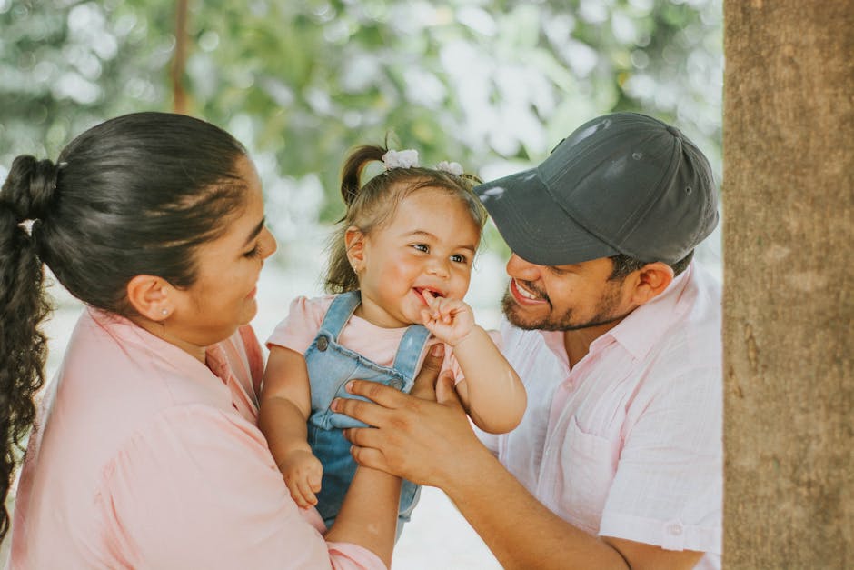 Smiling parents with baby enjoying a day outdoors in Guayaquil park.