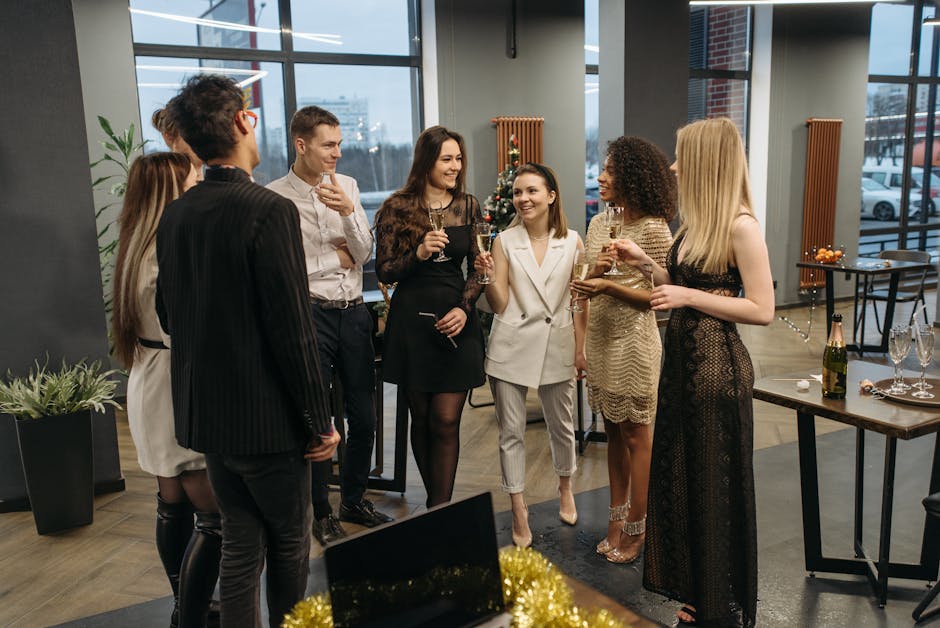 A diverse group of colleagues celebrating at an office party with drinks and laughter.