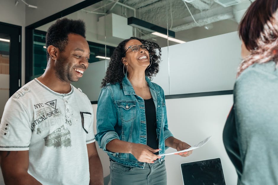 Smiling couple discussing with an advisor in a modern office setting.