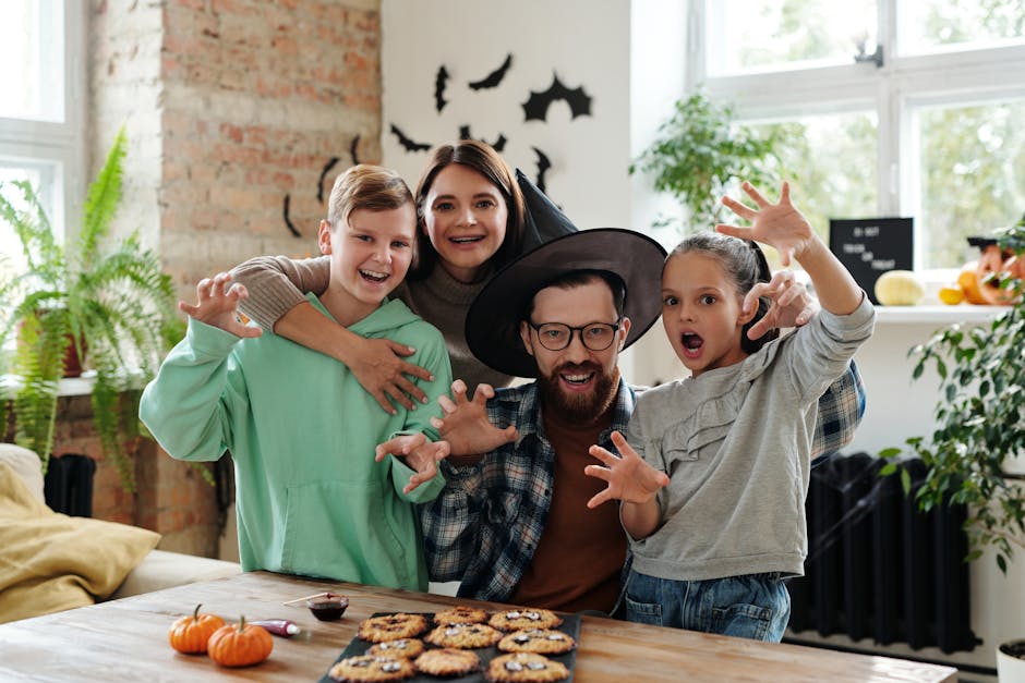 Joyful family having fun at home, celebrating Halloween with spooky cookies and decorations.