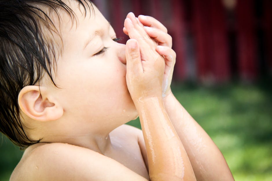 A close-up of a young child enjoying water play outdoors, capturing innocence and joy.