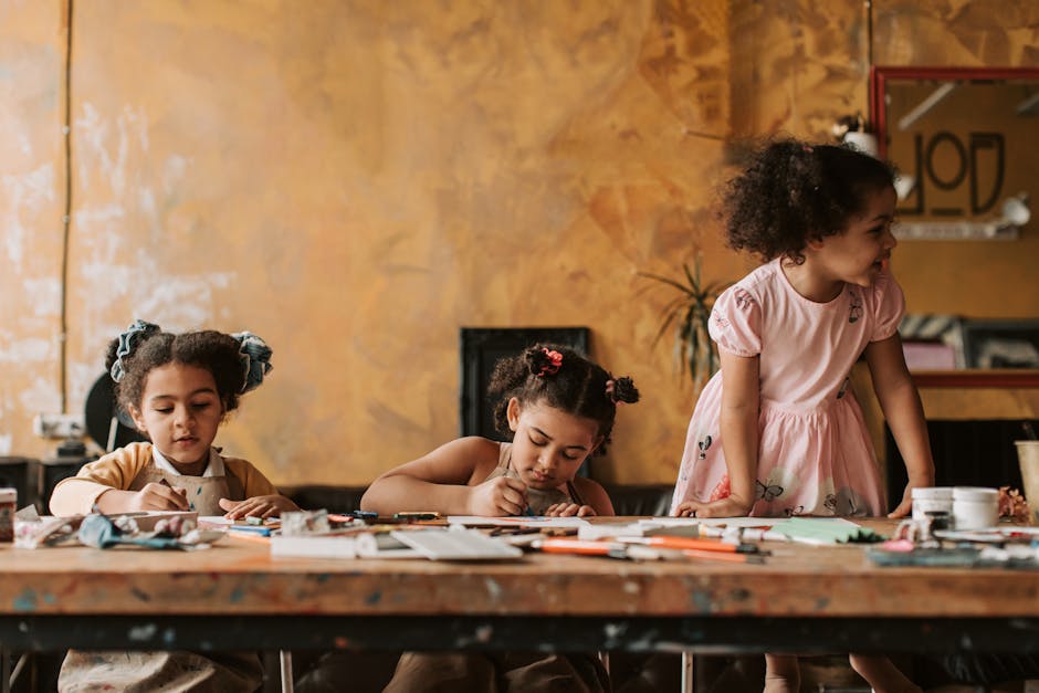 Three young girls enjoying arts and crafts at a table indoors, full of creativity and fun.