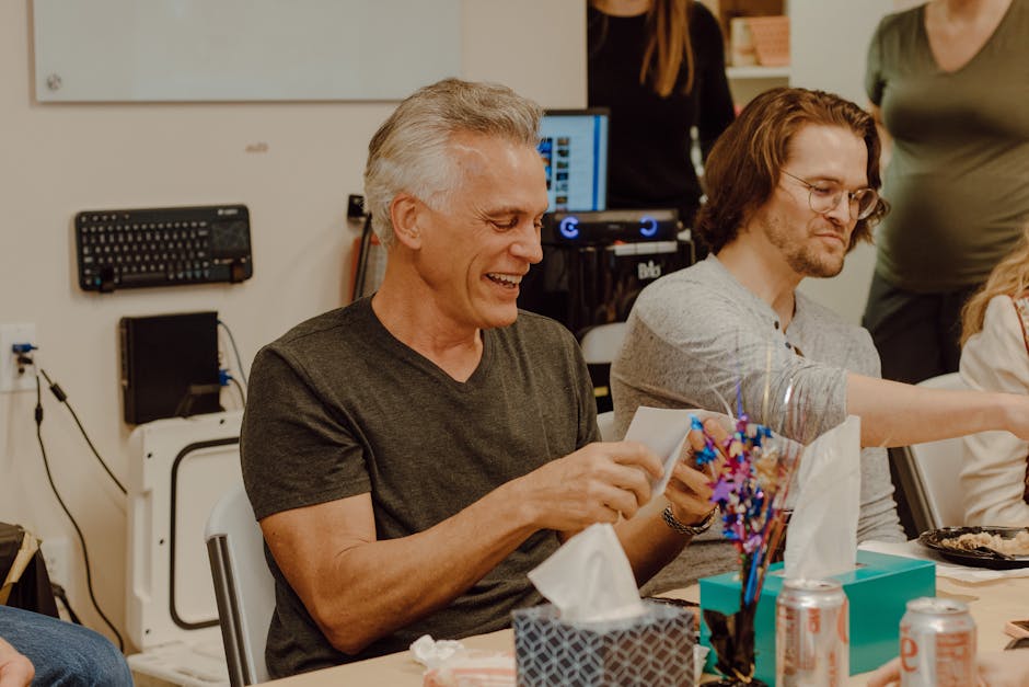 Two men enjoying a fun and relaxing moment during an office gathering, captured in a candid shot.