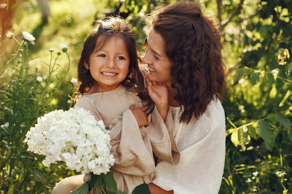 Joyful mother and daughter enjoying a sunny day with white flowers in hand.