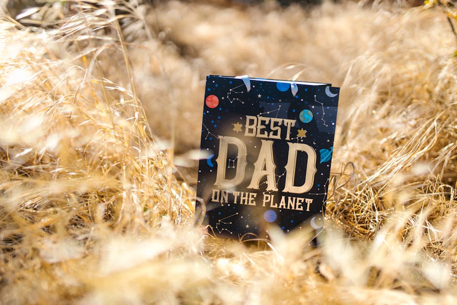 A 'Best Dad on the Planet' card amidst a field of dried grass, perfect for Father's Day gifts.