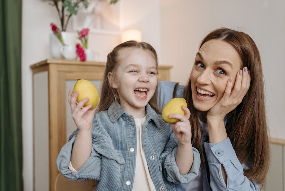A joyful mother and daughter smiling while holding lemons in a cozy indoor setting.