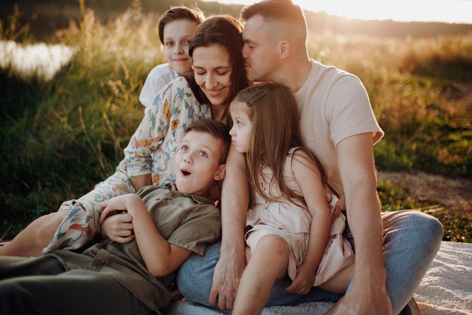 A joyful family enjoying quality time together on a sunset-lit meadow.