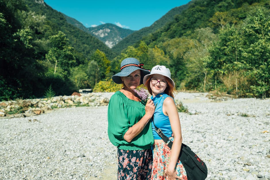 A joyful mother and daughter embrace surrounded by lush mountainous scenery in Гагра, highlighting family togetherness.