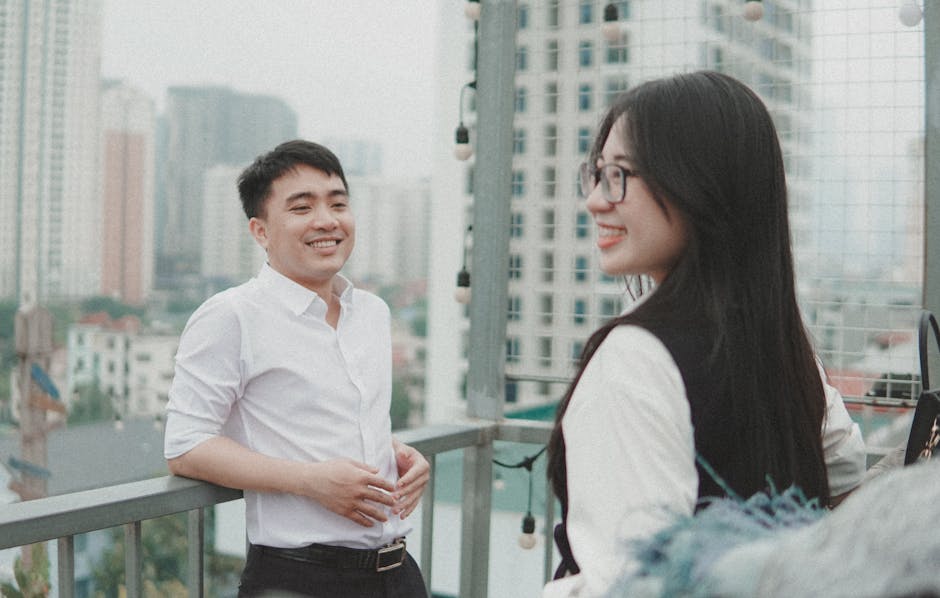 Two friends enjoying a lighthearted moment on a city rooftop, capturing genuine smiles.